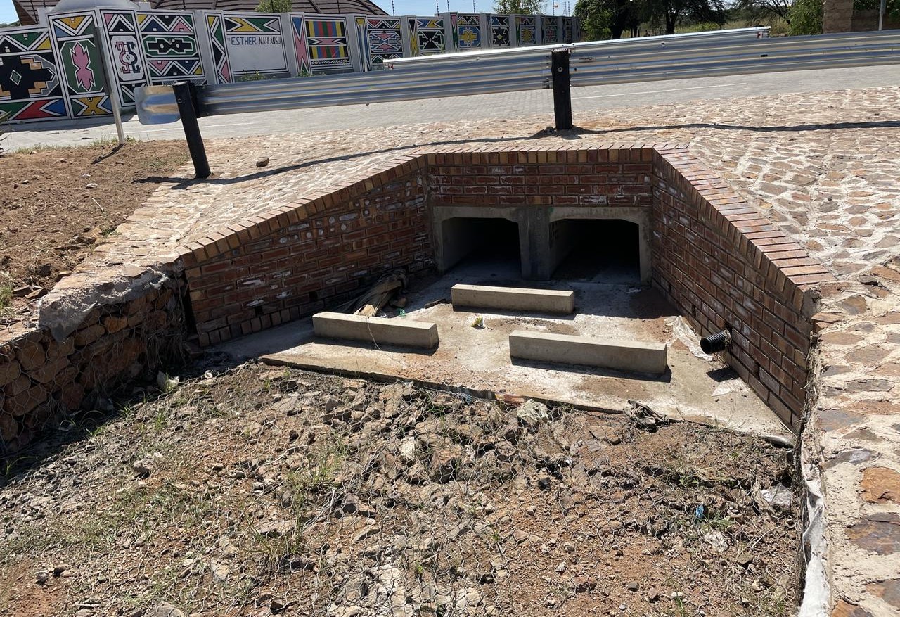 Twin-cell stormwater culvert with guardrail and Ndebele art wall