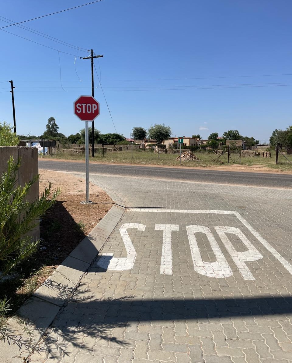 Stop sign and painted STOP marking on paved intersection